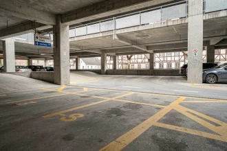 Parking structure moderne au centre-ville de Colmar avec places numérotées et marquage au sol jaune